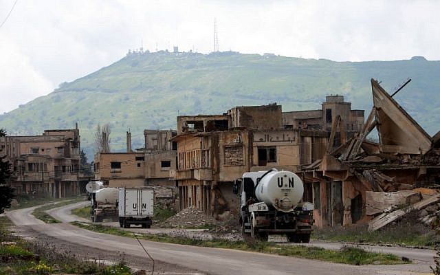 A convoy of UN vehicles drive through damaged buildings in the Syrian town of Quneitra, in the Golan Heights on March 26, 2019. (Louai Beshara/AFP) A convoy of UN vehicles drive through damaged buildings in the Syrian town of Quneitra, in the Golan Heights on March 26, 2019. (Louai Beshara/AFP)