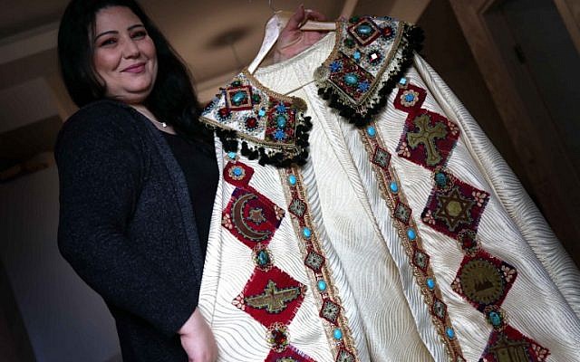 Iraqi Kurdish artist Shanaz Jamal, 40, poses with one of her embroidered robes ornated with religious symbols of communities of Iraq's multi-ethnic north, in Arbil, the capital of the Kurdish autonomous region, on March 27, 2019. (Photo by SAFIN HAMED / AFP)