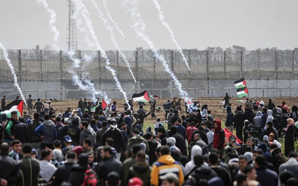 Tear gas canisters fall amongst Palestinians during a demonstration near the border with Israel, in Malaka east of Gaza City, on March 30, 2019 (Mahmud Hams/AFP)