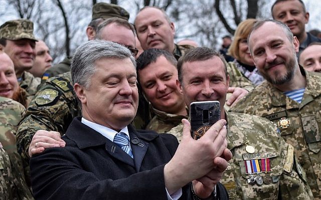 Ukrainian President Petro Poroshenko, left, takes a selfie with servicemen after an open air prayer for fair elections served by the priests of the Orthodox Church of Ukraine and the other confessions in Kiev, on March 30, 2019, on the eve of the Ukrainian presidential election. (Sergei Gapon/AFP) Ukrainian President Petro Poroshenko, left, takes a selfie with servicemen after an open air prayer for fair elections served by the priests of the Orthodox Church of Ukraine and the other confessions in Kiev, on March 30, 2019, on the eve of the Ukrainian presidential election. (Sergei Gapon/AFP)