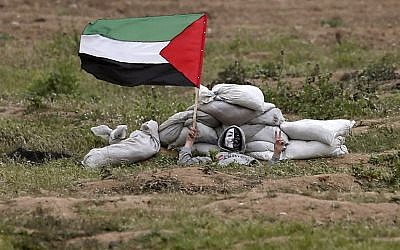 A Gazan protester waves a flag during clashes with Israeli forces on March 30, 2019. (MAHMUD HAMS / AFP)