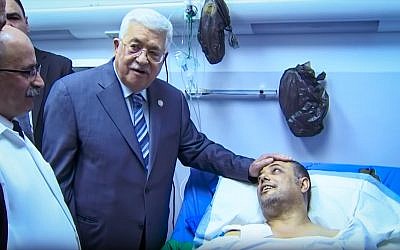 Palestinian Authority President Mahmoud Abbas visits an injured Fatah official, Atef Abu Seif, in Ramallah on March 20, 2019. (YouTube screen capture)