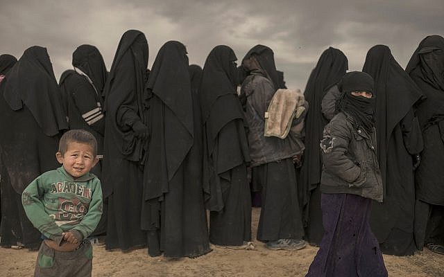 Women and children stand in line at a reception area for people evacuated from the last shred of territory held by Islamic State militants, outside Baghouz, Syria, on March 6, 2019. (AP/Gabriel Chaim) Women and children stand in line at a reception area for people evacuated from the last shred of territory held by Islamic State militants, outside Baghouz, Syria, on March 6, 2019. (AP/Gabriel Chaim)