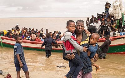 In this photo supplied by the Red Cross Red Crescent Climate Center, survivors of Cyclone Idai arrive by rescue boat in Beira, Mozambique, March 21, 2019. (Denis Onyodi - Red Cross Red Crescent Climate Center via AP)