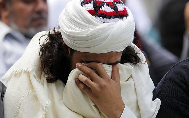 A Muslim man reacts during Friday prayers at Hagley Park in Christchurch, New Zealand, March 22, 2019. (AP Photo/Vincent Thian) A Muslim man reacts during Friday prayers at Hagley Park in Christchurch, New Zealand, March 22, 2019. (AP Photo/Vincent Thian)