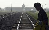 A man crosses the iconic rails leading to the former Nazi death camp of Auschwitz-Birkenau in Poland, July 29, 2016. (AP Photo/Alik Keplicz, FILE)