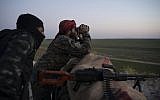 In this Tuesday, Feb. 19, 2019 file photo, US-backed Syrian Democratic Forces fighters watch as an airstrike hits territory still held by Islamic State in the desert outside Baghouz, Syria (AP Photo/Felipe Dana, File)
