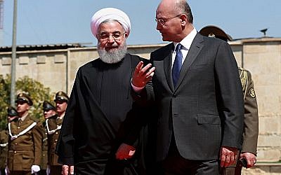 Iraqi President Barham Salih, right, walks with visiting Iranian President Hassan Rouhani, after inspecting an honor guard at Salam Palace, Baghdad, March 11, 2019. (AP/Khalid Mohammed)