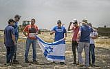 Israeli relatives hold the national flag at the crash site of an Ethiopian Airlines Boeing 737 Max 8, seen here on March 14, 2019. (Mulugeta Ayene/AP)