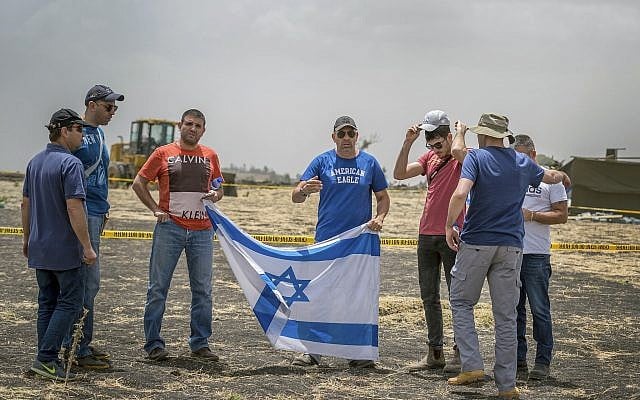 Israeli relatives hold the national flag at the crash site of an Ethiopian Airlines Boeing 737 Max 8, seen here on March 14, 2019. (Mulugeta Ayene/AP) Israeli relatives hold the national flag at the crash site of an Ethiopian Airlines Boeing 737 Max 8, seen here on March 14, 2019. (Mulugeta Ayene/AP)