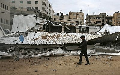 A Palestinian inspects the damage at the Hamas Prisoners Ministry after Israeli airstrike, Gaza City, March 15, 2019 (AP Photo/Adel Hana)