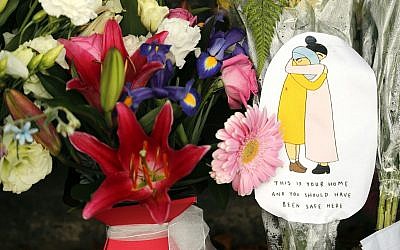 A message card is placed at a collection of flowers left at the Botanical Gardens in Christchurch, New Zealand, March 16, 2019. (Vincent Thian/AP)