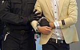 Alaa S, right, who is suspected of being responsible for the stabbing of Daniel Hillig in Chemnitz, escorted by a police officer as he arrives for the start of his trial at the court in Dresden, Germany, March 18, 2019. (Matthias Rietschel/AP)