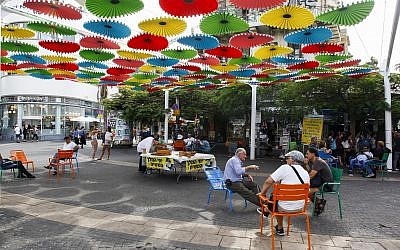 People sit outside the Carmel market in Tel Aviv, on October 22, 2018. (Sliman Khader/ Flash90)