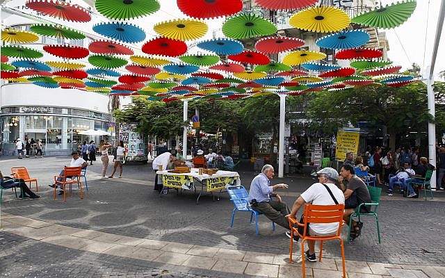 People sit outside the Carmel market in Tel Aviv, on October 22, 2018. (Sliman Khader/ Flash90)