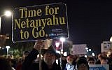 An Israeli man carries a sign citing conservative New York Times opinion columnist Bret Stephens as hundreds protest against Prime Minister Benjamin Netanyahu, Tel Aviv, March 02, 2019 (Gili Yaari/Flash90)