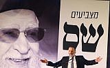 Aryeh Deri speaks in front of a picture of the late Rabbi Ovadia Yosef during a conference of the Shas party in the southern Israeli city of Ashdod on March 5, 2019. (Flash90)
