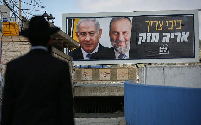 An ultra-Orthodox Jewish man near a billboard with pictures of Prime Minister Benjamin Netanyahu and Shas head Aryeh Deri, as part of the Shas election campaign, in Safed, March 10, 2019. (David Cohen/Flash90) An ultra-Orthodox Jewish man near a billboard with pictures of Prime Minister Benjamin Netanyahu and Shas head Aryeh Deri, as part of the Shas election campaign, in Safed, March 10, 2019. (David Cohen/Flash90)