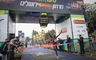 Ronald Kimeli, 33, from Kenya, crosses the finish line first at the 2019 international Jerusalem Marathon with a time of 02:18:47, on March 15, 2019. (Noam Revkin Fenton/Flash90)