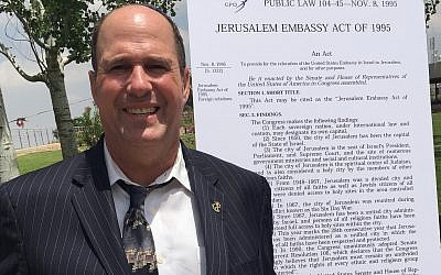 Farley Weiss, president of the National Council of Young Israel, poses next to the text of the Jerusalem Embassy Act of 1995. Weiss says political activism is part of Young Israel’s mission. (Courtesy of Weiss/via JTA)