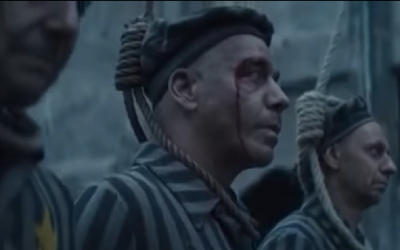 Members of German hard rock band Rammstein dressed as concentration camp inmates standing on a gallows, in a video for a new single released March 26, 2019 (YouTube screenshot)