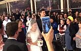 Tamar Fuld flanked by her mother, Miriam and brother Yakir, walks towards the huppah at her wedding on March 3, 2019. (Screen capture: Twitter)