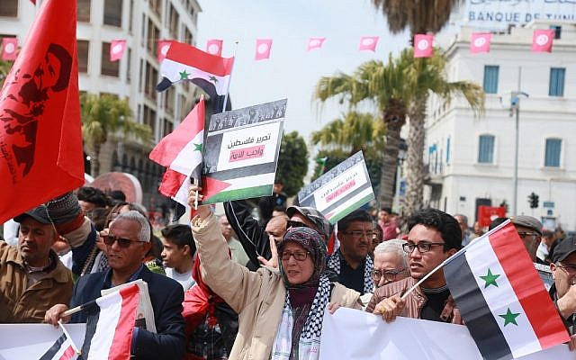 Tunisians hold Syrian and Palestinian flags, as they demonstrate against the Arab League Summit and the United States' recognition of Israeli sovereignty over the Golan Heights, on Habib Bourguiba Avenue, in the capital Tunis on March 31, 2019. (Anis Mili/AFP) Tunisians hold Syrian and Palestinian flags, as they demonstrate against the Arab League Summit and the United States' recognition of Israeli sovereignty over the Golan Heights, on Habib Bourguiba Avenue, in the capital Tunis on March 31, 2019. (Anis Mili/AFP)