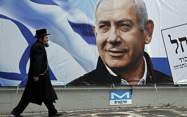 An ultra-Orthodox Jewish man walks past an electoral billboard bearing a portrait of Prime Minister Benjamin Netanyahu, in Jerusalem, on April 1, 2019. (Thomas Coex/AFP) An ultra-Orthodox Jewish man walks past an electoral billboard bearing a portrait of Prime Minister Benjamin Netanyahu, in Jerusalem, on April 1, 2019. (Thomas Coex/AFP)