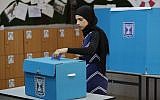 Illustrative: An Arab Israeli woman casts her vote during elections for the Knesset on April 9, 2019, at a polling station in the northern town of Tayibe. (Ahmad Gharabli/AFP)
