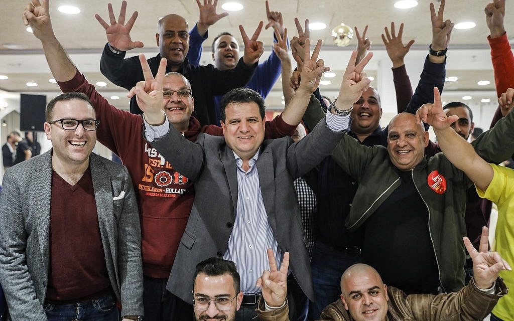 Israeli Arab politician Ayman Odeh (c) of the Hadash party flashes the victory gesture as he reacts at the party's headquarters in Nazareth in northern Israel on election tonight on April 9, 2019. (AFP/Ahmad Gharabli)