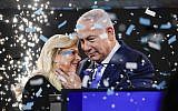 Prime Minister Benjamin Netanyahu embraces his wife Sara amid confetti during his victory speech before supporters at Likud party headquarters in Tel Aviv after April 9, 2019's elections. (Thomas Coex/AFP)