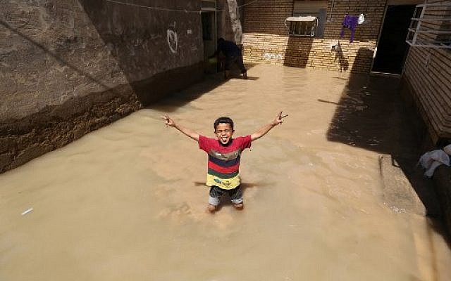 An Iranian child gestures for the camera at a flooded house in the city of Hamidiyeh, in Iran's Khuzestan province, on April 10, 2019.(ATTA KENARE / AFP) An Iranian child gestures for the camera at a flooded house in the city of Hamidiyeh, in Iran's Khuzestan province, on April 10, 2019.(ATTA KENARE / AFP)