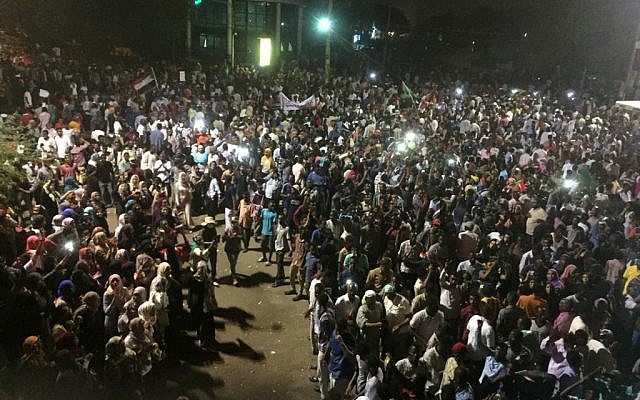 Sudanese demonstrators chant slogans as they gather at night during a demonstration in front of the military headquarters in the capital Khartoum on April 10, 2019. (AFP) Sudanese demonstrators chant slogans as they gather at night during a demonstration in front of the military headquarters in the capital Khartoum on April 10, 2019. (AFP)