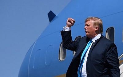 US President Donald Trump pumps his fist as he steps off Air Force One upon arrival at Ellington Field Joint Reserve Base in Houston, Texas, on April 10, 2019. (Photo by Jim WATSON / AFP)