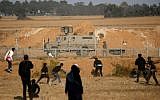Illustrative: Palestinians confront Israeli forces near the border with Israel, east of Khan Younis in the southern Gaza Strip, on April 12, 2019. (Said Khatib/AFP)