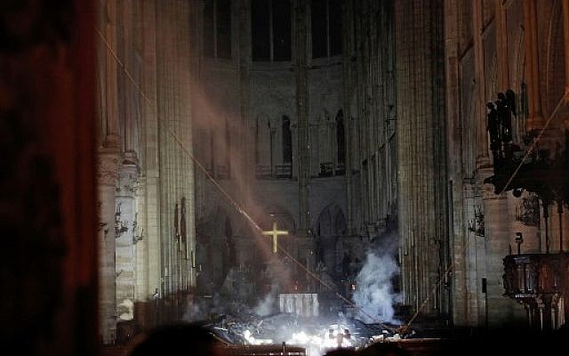 Smoke rises in front of the altar cross at Notre Dame Cathedral in Paris on April 15, 2019, after a fire engulfed the building. (PHILIPPE WOJAZER / POOL / AFP) Smoke rises in front of the altar cross at Notre Dame Cathedral in Paris on April 15, 2019, after a fire engulfed the building. (PHILIPPE WOJAZER / POOL / AFP)