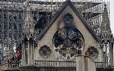 Inspectors are seen on the roof of the landmark Notre Dame Cathedral in central Paris on April 16, 2019, the day after a fire ripped through its main roof. (Photo by Lionel BONAVENTURE / AFP)