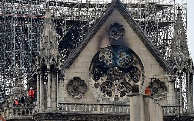 Inspectors are seen on the roof of the landmark Notre Dame Cathedral in central Paris on April 16, 2019, the day after a fire ripped through its main roof. (Photo by Lionel BONAVENTURE / AFP) Inspectors are seen on the roof of the landmark Notre Dame Cathedral in central Paris on April 16, 2019, the day after a fire ripped through its main roof. (Photo by Lionel BONAVENTURE / AFP)