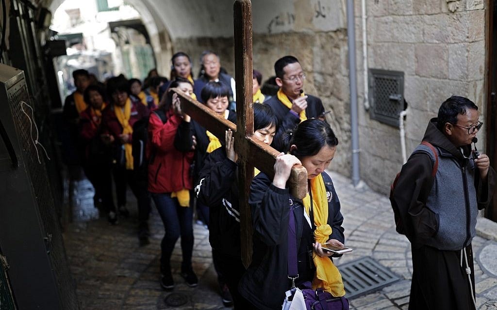 Chinese Catholic pilgrims carry a wooden cross along the Via Dolorosa in Jerusalem's Old City during the Good Friday procession on April 19, 2019. (Thomas Coex/AFP)