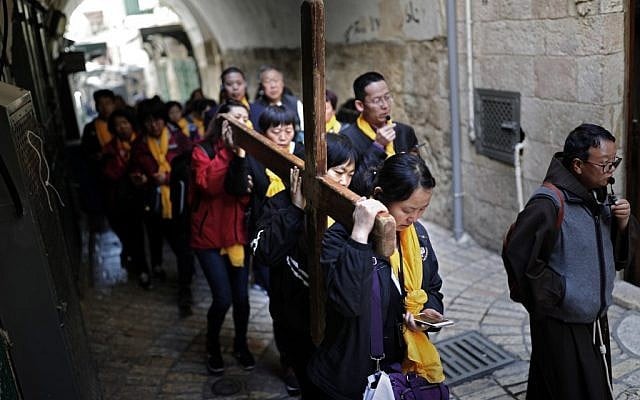 Chinese Catholic pilgrims carry a wooden cross along the Via Dolorosa in Jerusalem's Old City during the Good Friday procession on April 19, 2019. (Thomas Coex/AFP) Chinese Catholic pilgrims carry a wooden cross along the Via Dolorosa in Jerusalem's Old City during the Good Friday procession on April 19, 2019. (Thomas Coex/AFP)