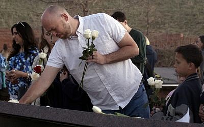 Will Beck, a Columbine High School massacre survivor, places flowers at the Columbine Memorial at Clement Park in Littleton, Colorado, during a community vigil for the 20th anniversary of the Columbine High School mass shooting on April 19, 2019. (Jason Connolly / AFP)