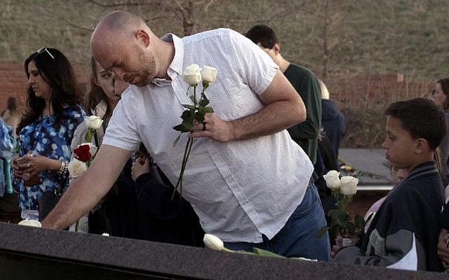 Will Beck, a Columbine High School massacre survivor, places flowers at the Columbine Memorial at Clement Park in Littleton, Colorado, during a community vigil for the 20th anniversary of the Columbine High School mass shooting on April 19, 2019. (Jason Connolly / AFP) Will Beck, a Columbine High School massacre survivor, places flowers at the Columbine Memorial at Clement Park in Littleton, Colorado, during a community vigil for the 20th anniversary of the Columbine High School mass shooting on April 19, 2019. (Jason Connolly / AFP)
