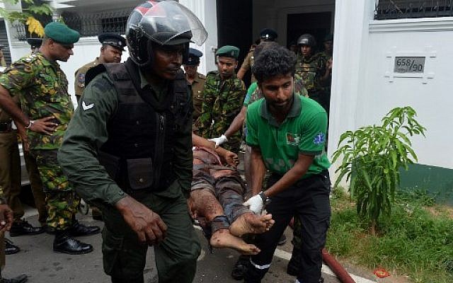 An injured Sri Lankan Special Task Force (STF) member is carried by colleagues after a blast in a house, which was detonated as security forces searched the property, in the Orugodawatta area of the capital Colombo on April 21, 2019.(ISHARA S. KODIKARA / AFP)