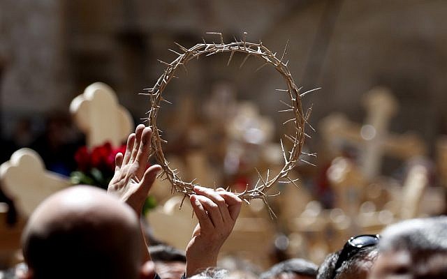 Orthodox Christians brandish the crown of thorns in the Church of the Holy Sepulchre after they celebrated the Good Friday in a procession on Via Dolorosa in the Old City of Jerusalem, on April 26, 2019. (THOMAS COEX / AFP)