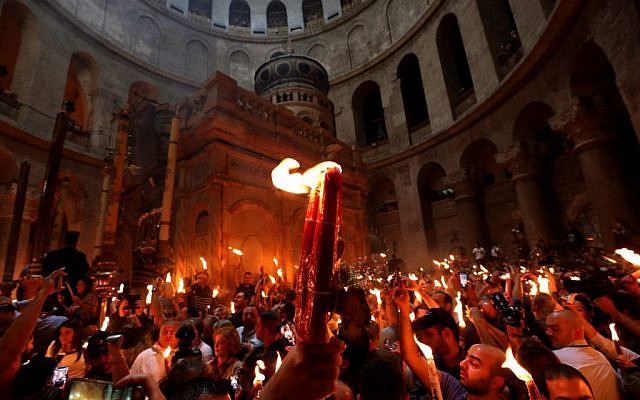 Christian Orthodox worshippers hold up candles lit from theHoly Fire as they gather in the Church of the Holy Sepulchre in Jerusalems Old City on April 27, 2019 during the Orthodox Easter. (GALI TIBBON / AFP) Christian Orthodox worshippers hold up candles lit from theHoly Fire as they gather in the Church of the Holy Sepulchre in Jerusalems Old City on April 27, 2019 during the Orthodox Easter. (GALI TIBBON / AFP)