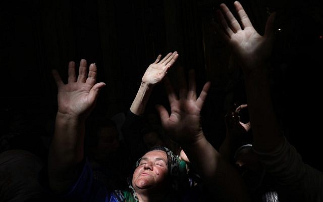 Christian Orthodox worshippers raise their hands as a beam of light from the Holy Fire penetrates in the Church of the Holy Sepulchre in Jerusalems Old City on April 27, 2019 during the Orthodox Easter. (GALI TIBBON / AFP) Christian Orthodox worshippers raise their hands as a beam of light from the Holy Fire penetrates in the Church of the Holy Sepulchre in Jerusalems Old City on April 27, 2019 during the Orthodox Easter. (GALI TIBBON / AFP)