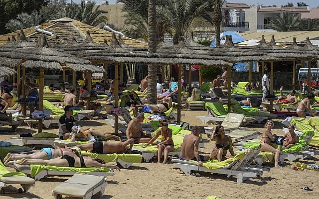 In this file photo taken on April 3, 2019, tourists sunbathe on a beach in Egypt's Red Sea resort town of Hurghada. (Photo by Mohamed el-Shahed / AFP)