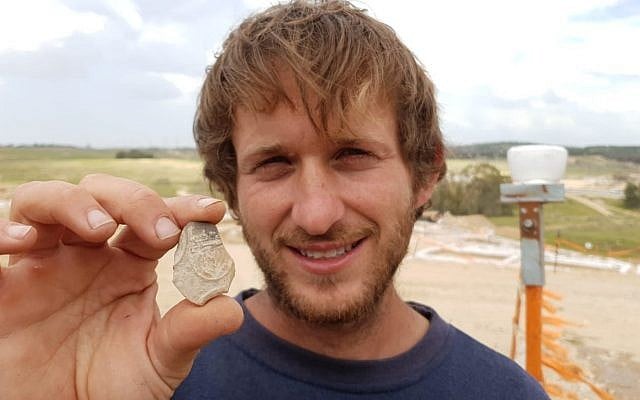IAA Archaeologist Avinoam Lehavi holding the 2000-year-old oil lamp sherd decorated with a menorah from the excavation near Tel Beersheba. (Anat Rasiuk, Israel Antiquities Authority)