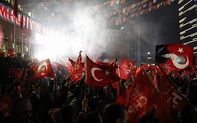 Supporters of the Republican People's Party, CHP, wave Turkish flags, and one with a portrait of Kemal Ataturk, right, as they celebrate after preliminary results of the local elections were announced in Ankara, Turkey, April 1, 2019. (Burhan Ozbilici/AP)