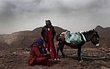 In this March 30, 2019 photo, Umm Yasser, the first Bedouin female guide from the Hamada tribe, looks at Umm Soliman as she plays the flute, near Wadi Sahw, Abu Zenima, in South Sinai, Egypt. (AP Photo/Nariman El-Mofty)